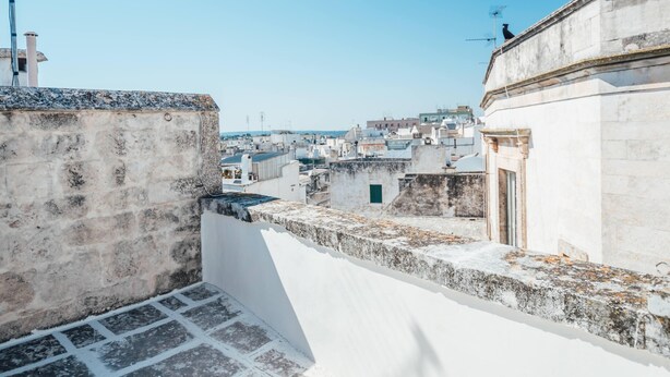 A rooftop view of a densely packed urban area with stone walls and buildings.