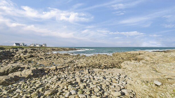 A rocky beach with white buildings in the background. - Surf & swimming – 300 m from Pors Carn beach (Penmarch)