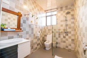 A modern bathroom with a glass-enclosed shower, a white sink, and a toilet. - HOTEL LA VENA (Kampala)