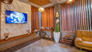 Un salon moderne doté d’un grand téléviseur à écran plat, de meubles en bois, d’un canapé et d’objets décoratifs.