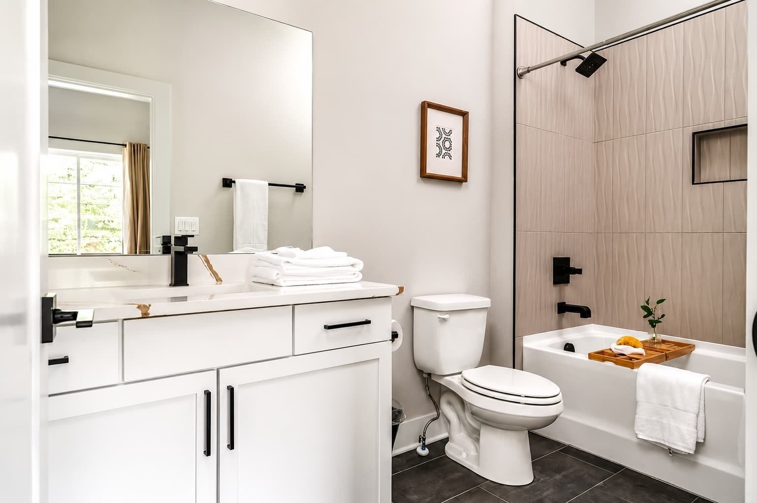 A modern bathroom with a toilet, sink, and bathtub.
