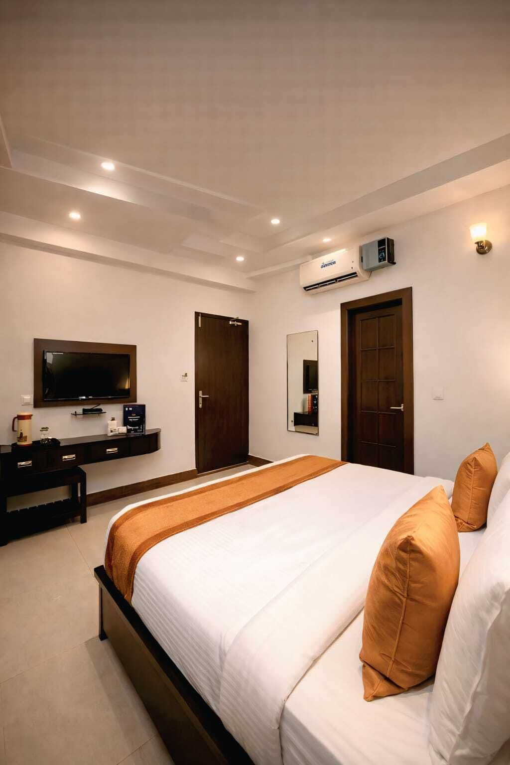 Una camera d'albergo con un letto, una televisione, una scrivania e un armadio.