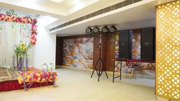 Um palco com decoração floral, sistema de som e parede estampada.