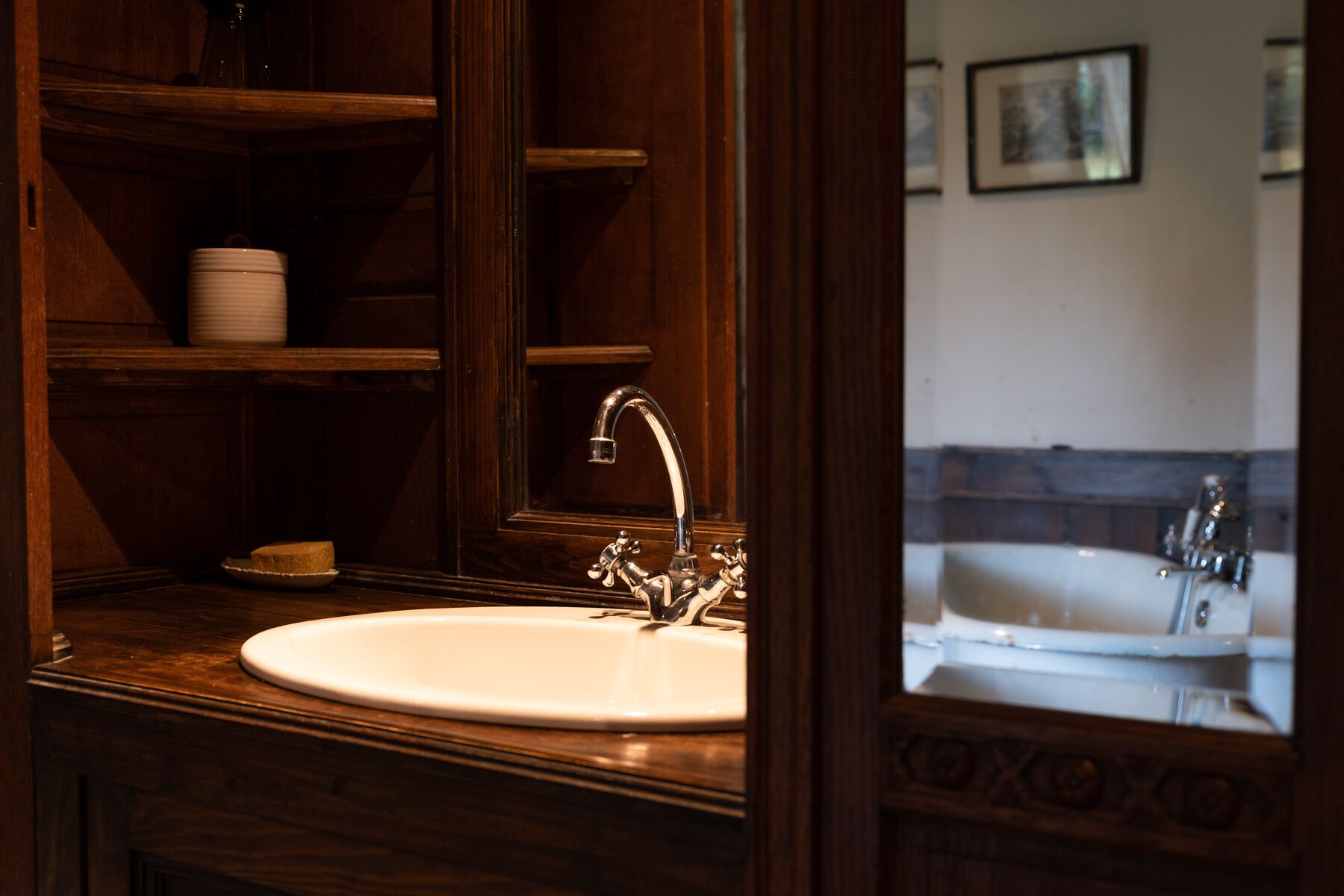 A bathroom with a wooden vanity, a sink, and a mirror.