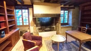A cozy room with a fireplace, wooden furniture, and bookshelves.