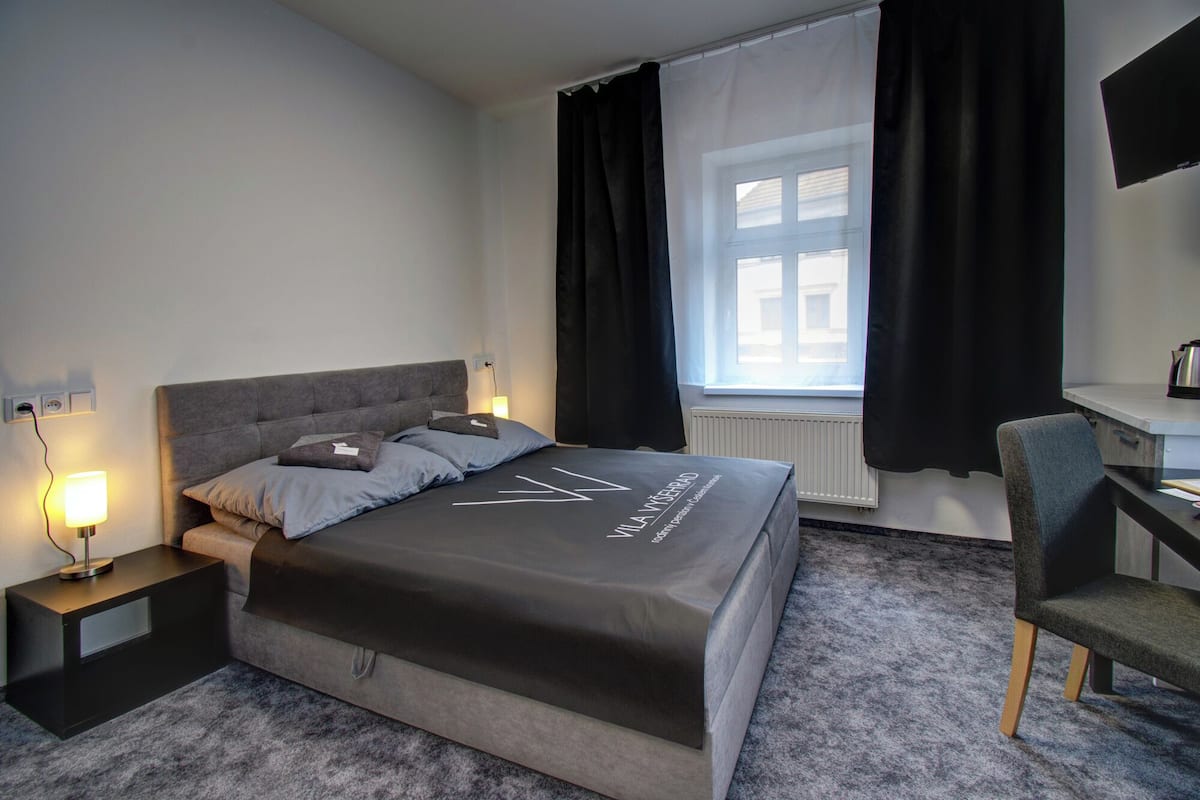 Een moderne hotelkamer met een groot bed, een bureau en een stoel.
