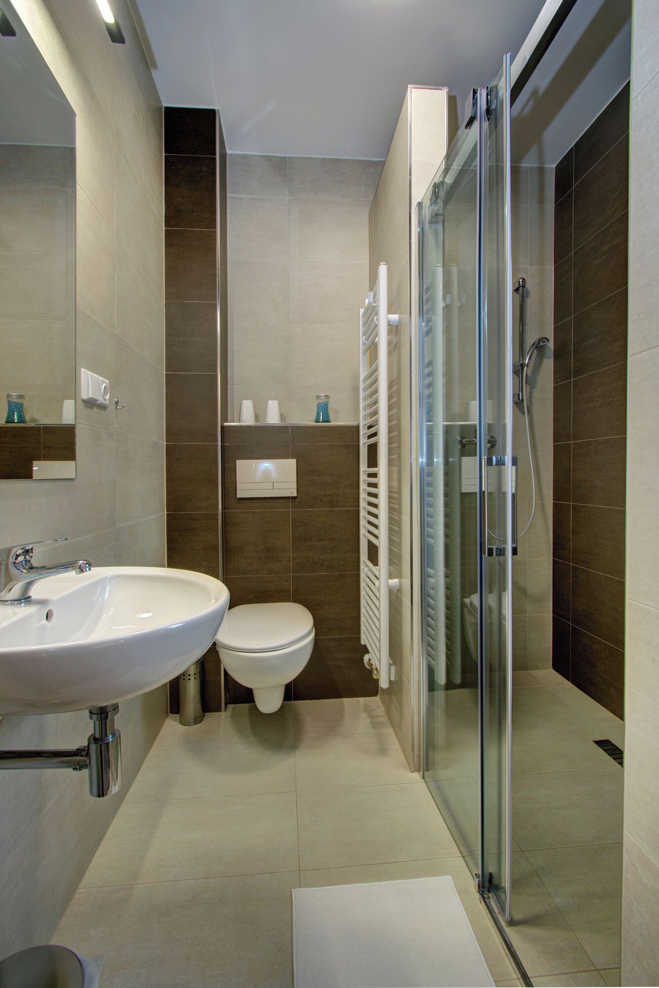 Un baño moderno con ducha envuelta en vidrio, un lavabo blanco y un inodoro.