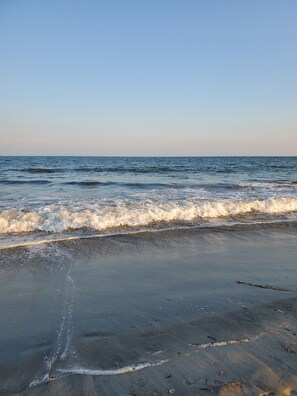 A beach with waves gently lapping onto the shore.