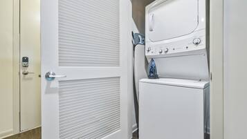 Un lavadero con una puerta blanca, una secadora y una lavadora.