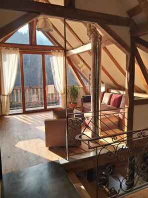Una camera da letto mansardata accogliente con un'ampia finestra, un balcone e vista sull'esterno.