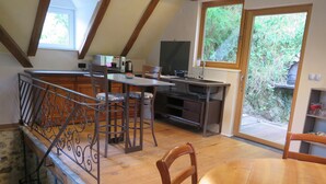 Una cocina moderna con comedor, suelo de madera y vista a zonas verdes.