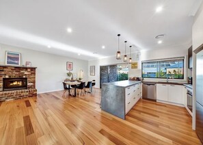 Enjoy meals in the kitchen with a central island, fireplace, and dining table.