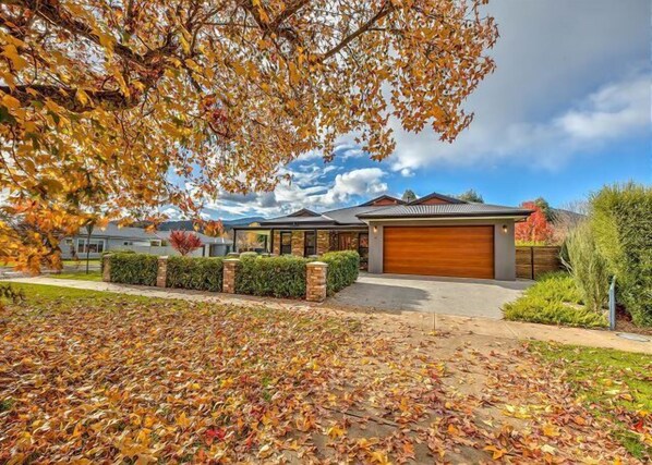 Set back from the street, this two-story house offers a retreat surrounded by a well-maintained lawn and lush foliage.