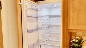 Una cucina con frigorifero integrato, mobili in legno e un piano lavoro con un'esposizione di fiori.