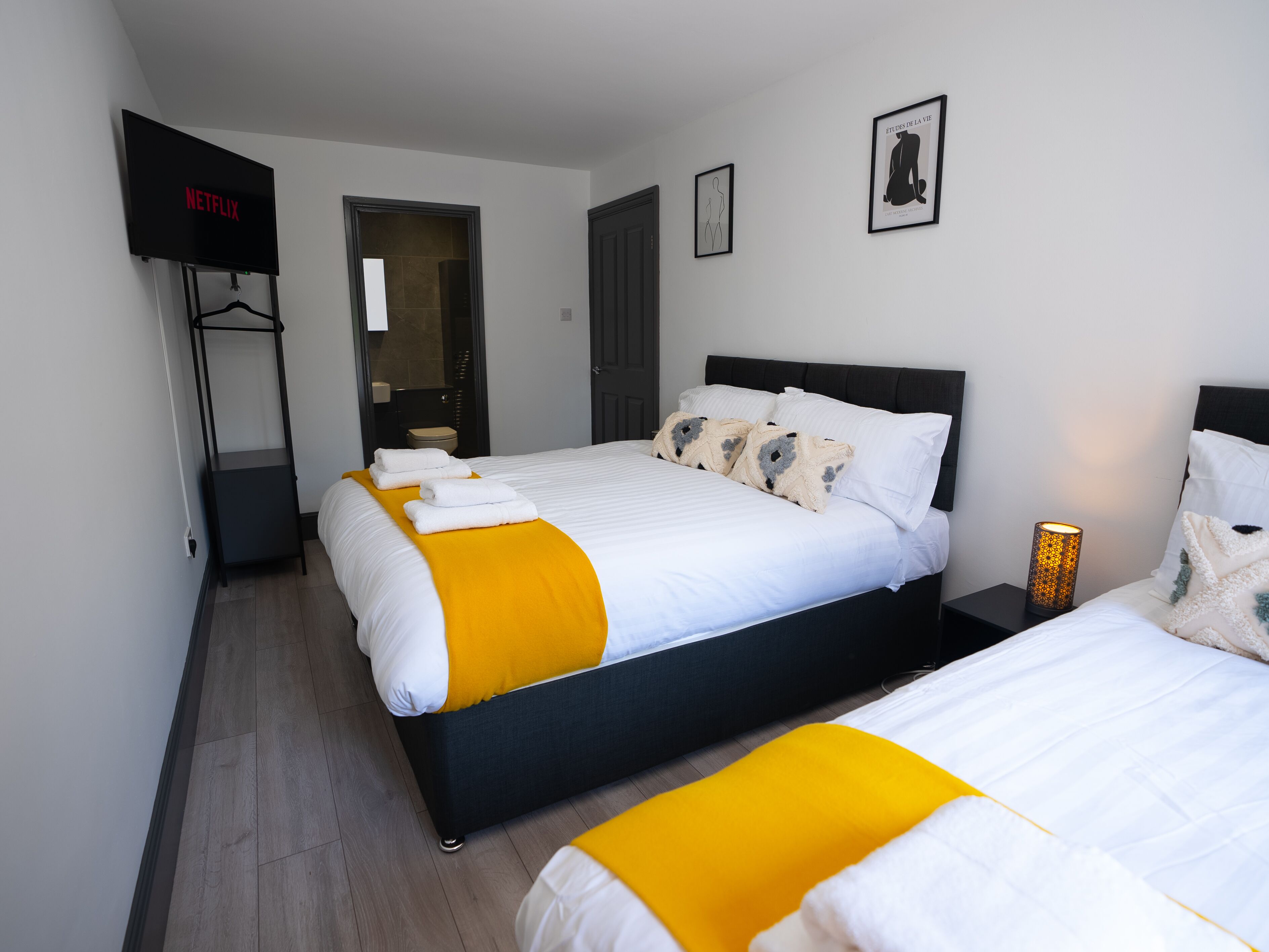 Een hotelkamer met een bed, een televisie, een kledingkast en een badkamer.