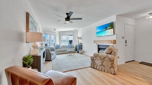 Un salon moderne avec un canapé, un fauteuil et une cheminée.