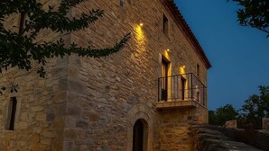 Un bâtiment en pierre doté d’un balcon, et une lune dans le ciel.
