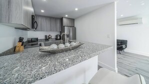 Eine moderne Küche mit Granit Arbeitsplatten, Edelstahlgeräten und einem eleganten Design.