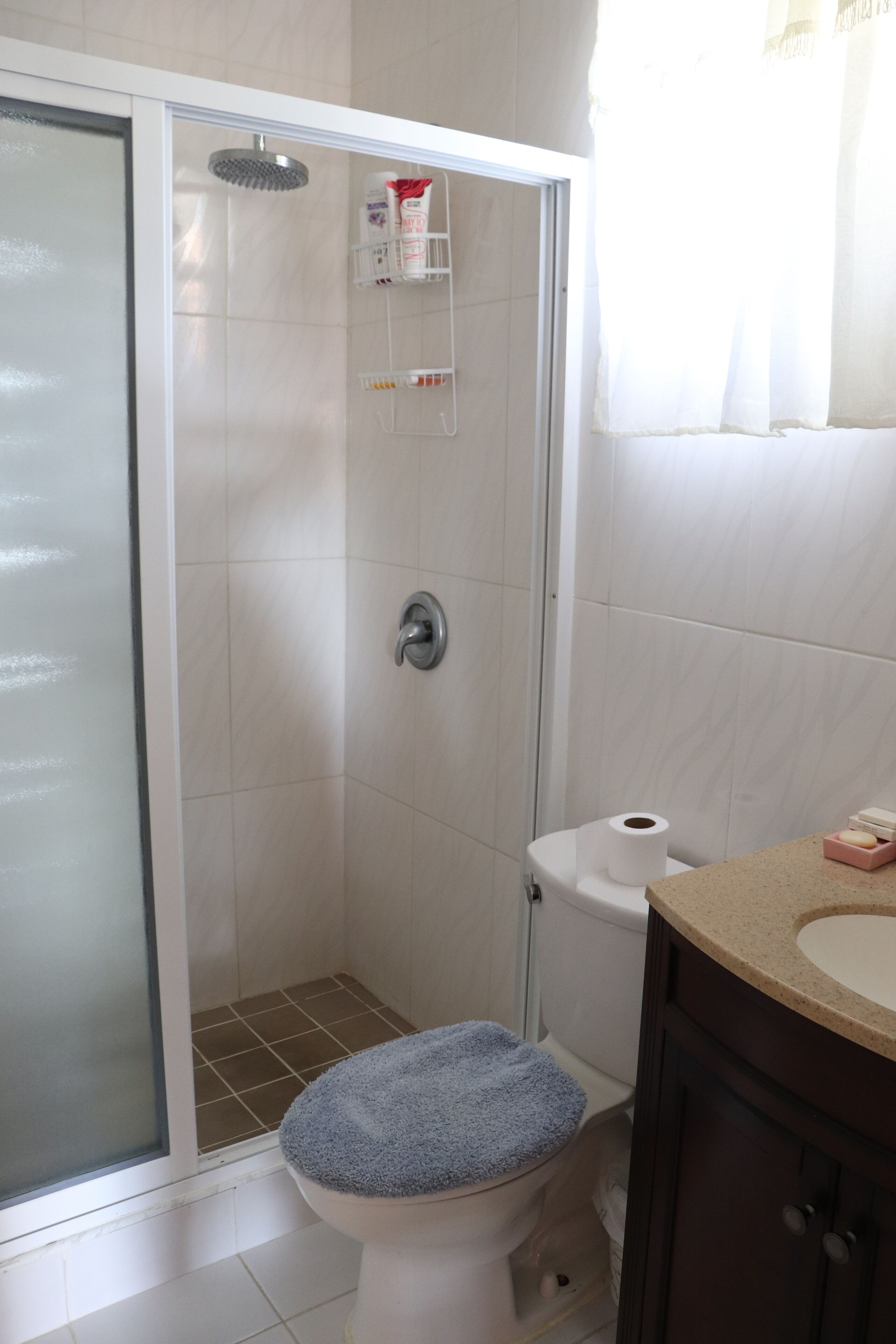 A bathroom with a shower, toilet, and sink.