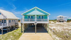 A beachfront house with a balcony, a covered walkway, and a sandy beach in the background. - Gulf Views | Private Pool | Pet Friendly | Beach Access (Gulf Shores)