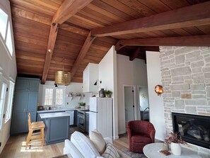 A spacious living area with a fireplace, a kitchen with a central island, and a dining area.