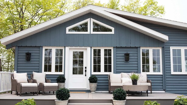 A blue house with a porch, white door, and windows. - Koselig Cottage: Charming 1950s Danish Cottage on 5 Acres (Ellison Bay)