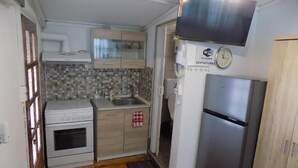 Une cuisine de taille réduite équipée d’une cuisinière, d’un four, d’un évier et d’un réfrigérateur.