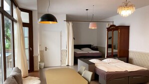 A modern room with a bed, a desk, a chair, a sofa, and a dining table. - Hotel Lux (Regensburg)