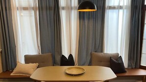 A dining area with a table, chairs, and a floor lamp. - Hotel Lux (Regensburg)