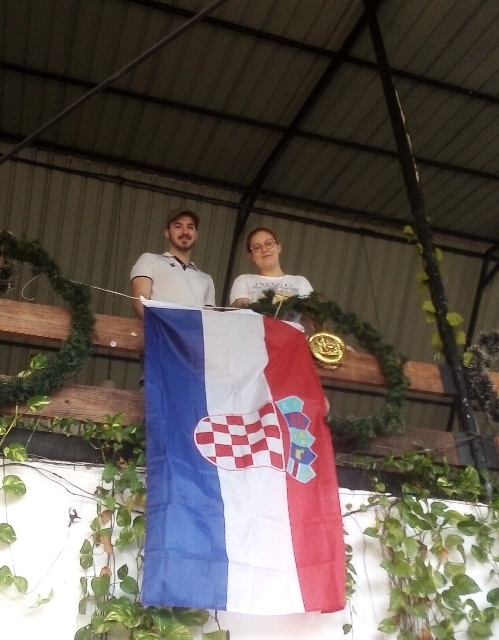 Two people standing behind a podium with a flag.