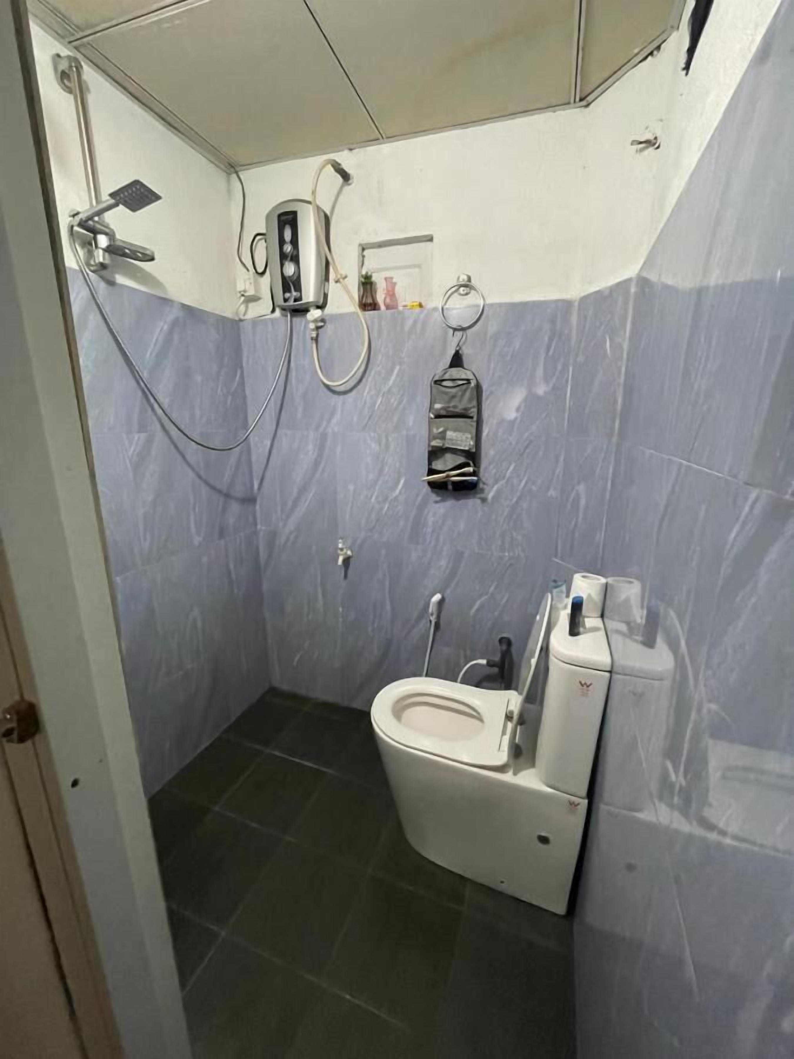 A small bathroom with a toilet, a shower, and a sink.