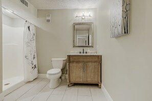A bathroom with a toilet, sink, and shower curtain.