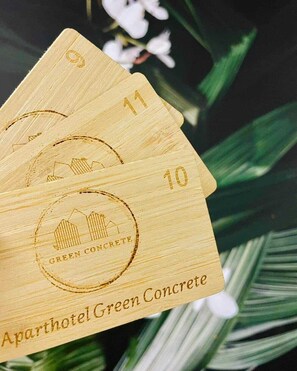 A set of wooden cards with embossed numbers and the text "Aparthotel Green Concrete."