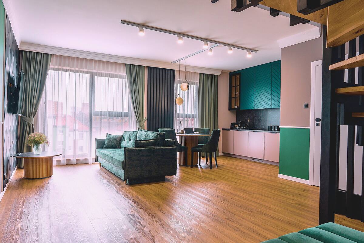 Una sala de estar moderna con un sofá, una mesa de comedor y una zona de cocina.