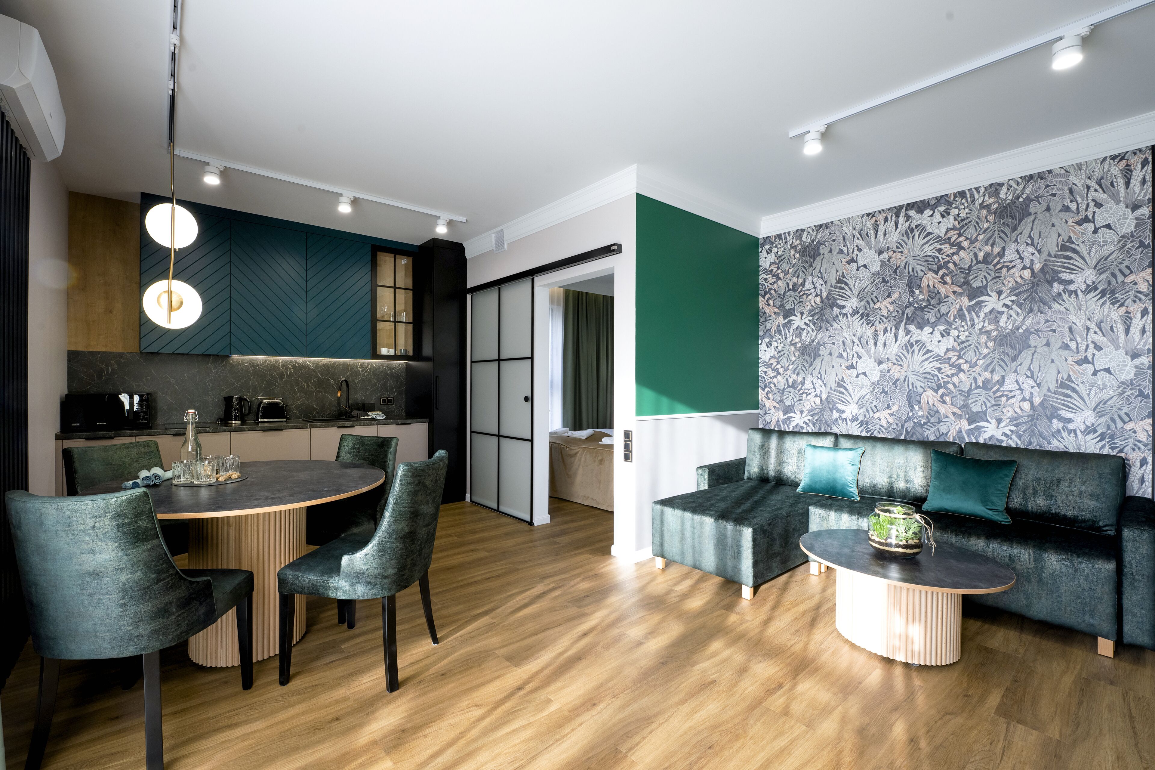 Un salon moderne avec une table de salle à manger ronde, deux chaises, un canapé et une table basse.