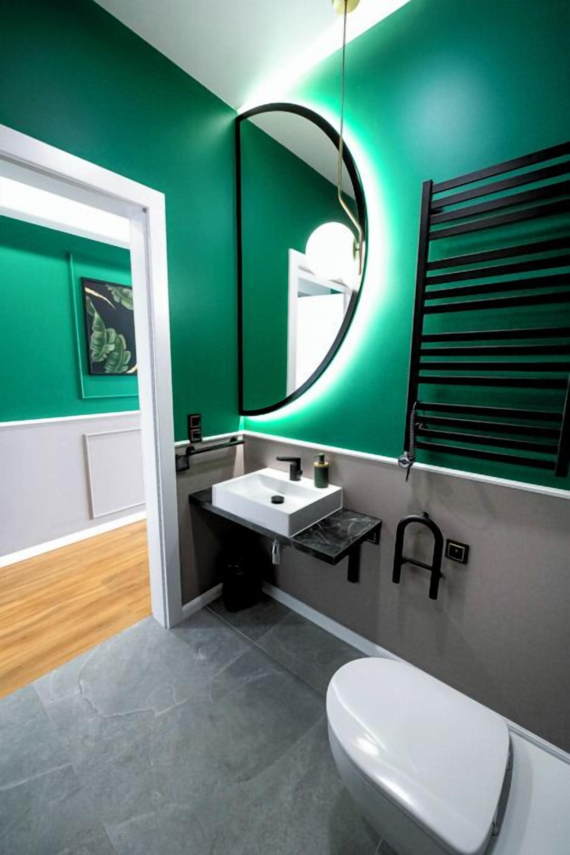 A modern bathroom with a white toilet, a sink, and a mirror.