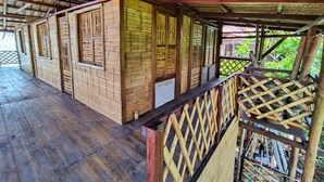 A covered wooden structure with a thatched roof and a wooden floor. - Hostal HALALIKU (Santa Marta)
