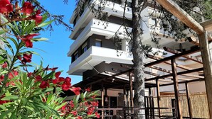 A multi-story building with balconies, surrounded by trees and a wooden pergola. - Albergo Terme Sant'Egidio (Castelforte)