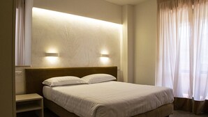 A hotel room with a bed, bedside tables, and a wall-mounted light fixture. - Albergo Terme Sant'Egidio (Castelforte)