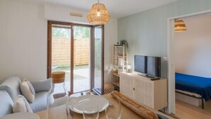 Un salon moderne avec un canapé, une table à manger et un téléviseur.