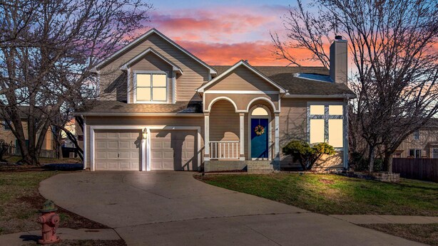 A two-story house with a garage, a front porch, and a blue door. - Entire 3-level, 3 BRM home w/King/Queen/Twin beds (Topeka)
