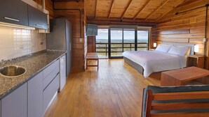 Een chalet van binnen met een keuken, een bed en een balkon met uitzicht.