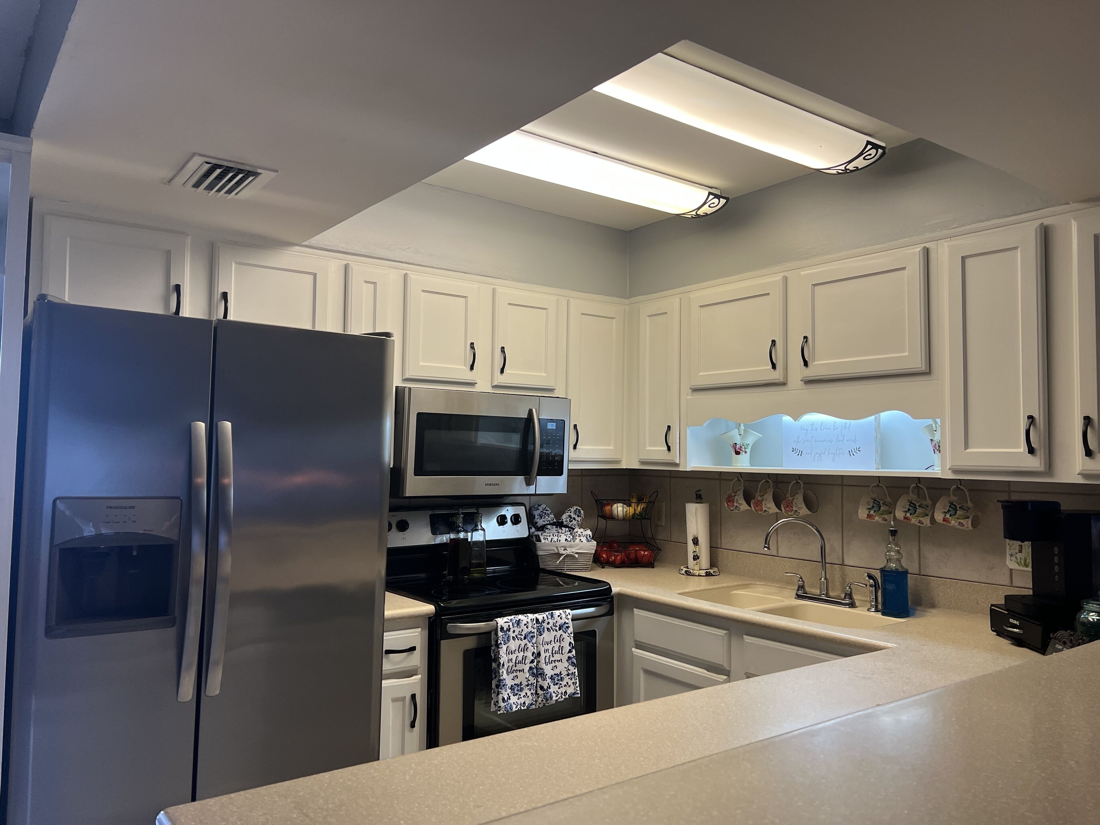 A kitchen with white cabinets, stainless steel appliances, and a countertop.