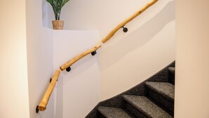 A wooden handrail with wheels attached to a staircase.