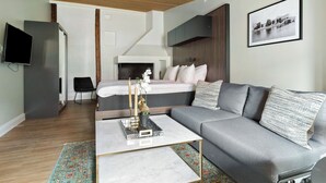 Una sala moderna con un sofá gris, una mesa de centro y una chimenea.
