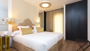 A hotel room with a large bed, a bedside table, a lamp, and a wardrobe. - Genteel Home Betis XVII (Seville)