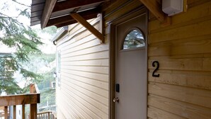 A wooden door with the number 2 on it, a small window above the door, and a wooden deck with a bench. - Mountainside 1BRM & Loft : Sleeps 4 ,Free Parking, Near Lakes, Restaurants & Shops! (Whistler)