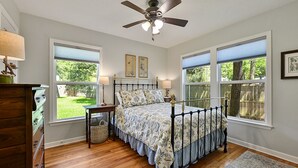A bedroom with a bed, two bedside tables, a ceiling fan, and large windows. - Visiting professor?  New to area?  Perfect for you! (College Station)