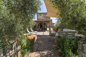 A courtyard with a stone pathway, outdoor furniture, and potted plants. - Casa Anita (Castellina in Chianti)