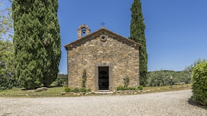 A small stone church with a bell tower, surrounded by tall cypress trees and a gravel path leading to the entrance. - Casa Anita (Castellina in Chianti)